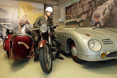 Ein Motorrad und ein alter silberner Oldtimer stehen im Museum für Sächsische Fahrzeuge in Chemnitz.