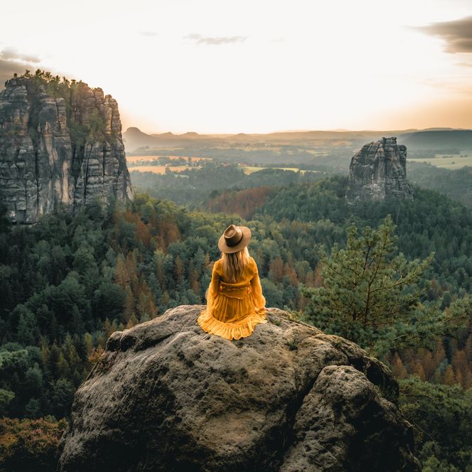 Frau sitzt auf Felsen in der Sächsischen Schweiz