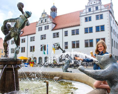 Bären und andere Figuren aus Stein spucken Wasser in den Brunnen vor dem Renaissancerathaus in Torgau.