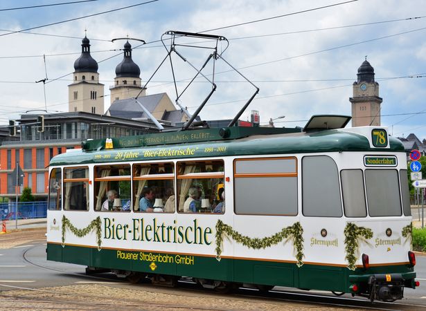 Ein Straßenbahnwaggon mit der Aufschrift "Bier-Elektrische" fährt durch Plauen. 