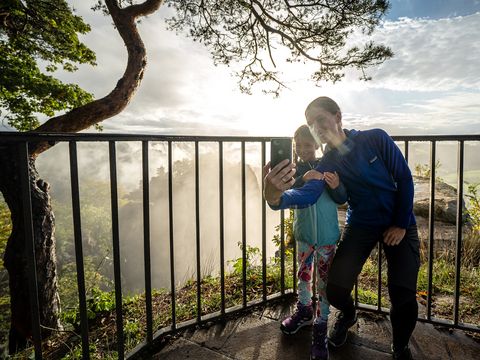 Mutter und Tochter machen ein Selfie auf einer Aussichtsplattform.