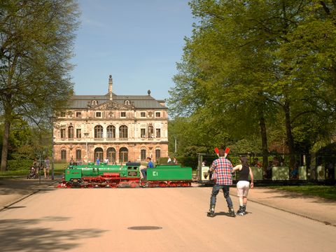 Großer Garten in Dresden, im Hintergrund kreuzt die Parkeisenbahn den Weg