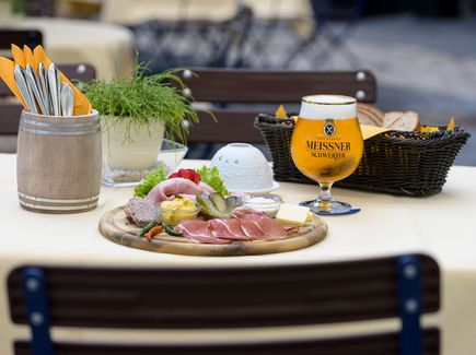 Tisch in einem Biergarten mit leckeren Speisen und einem Bier 