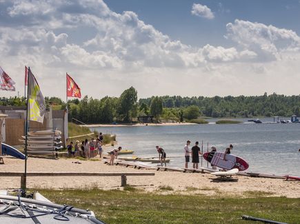 Am Strand vom Schladitzer See im Leipziger Neuseenland. Surfer und Stand-Up Paddler bereiten sich im See Camp David vor.