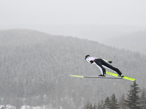 Skispringer springt in der Sparkassen Vogtland Arena im Winter