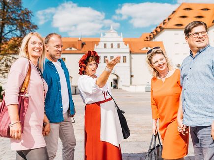 Gruppe bei einer Stadtführung mit einer Stadtführerin in einem historischen Gewand.