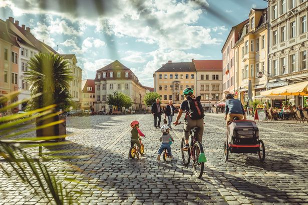 Eine Familie mit Fahrrädern in der Altstadt von Zittau. Die Stadt liegt am Oder-Neiße-Radweg.