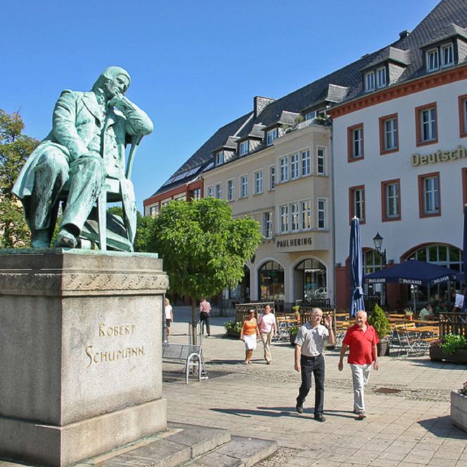 Am Hauptmarkt in Zwickau sitzt eine Statue von Robert Schumann auf einem Stuhl.