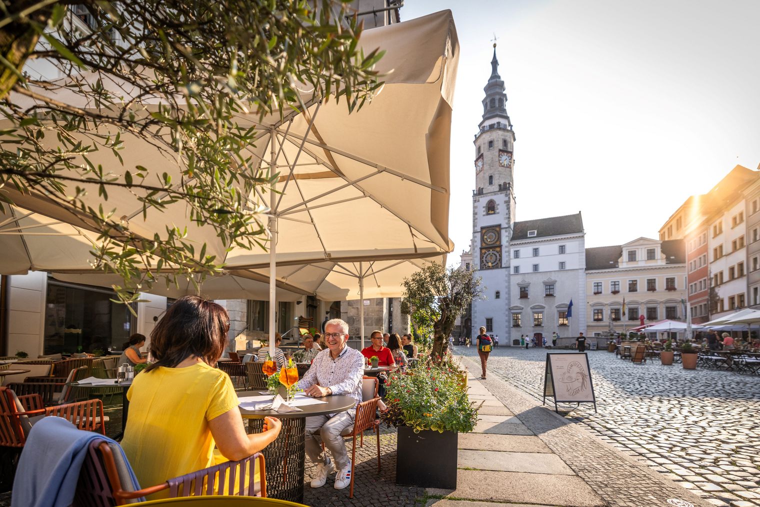 Paar im Restaurant auf dem Untermarkt in Görlitz im Sonnenschein / Couple in a restuarant on the Untermarkt in Görlitz in the sunshine