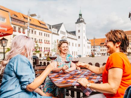  Frauen sitzen gemuetlich zusammen und genießen Wein 