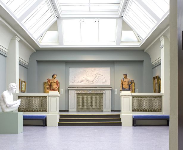 Menschliche Skulpturen stehen im weißen Galerieraum mit Glasdach im Museum von Bautzen. 