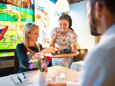 Essen wird in einem Restaurant serviert in traditioneller sorbischer Tracht