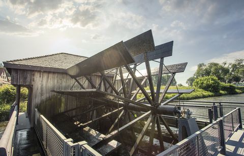  Wassermühle, die auf einem im Wasser schwimmenden Schiffskörper errichtet ist