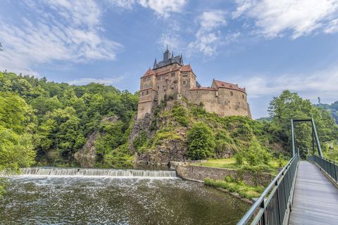 Über eine Brücke gelangt man zur Burg Kriebstein. Davor rauscht ein Wasserfall. 