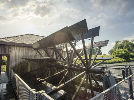  Wassermühle, die auf einem im Wasser schwimmenden Schiffskörper errichtet ist