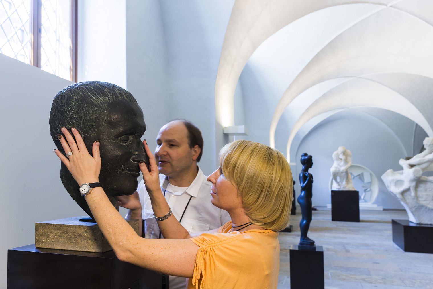 Eine Frau und ein Mann befühlen eine Skulptur eines Kopfes im Albertinum Dresden