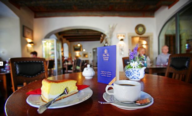 Auf einem Tisch in Ilses Kaffeestube stehen eine Eierschecke und eine Tasse Kaffee. Die Kaffeestube ist im Tom Pauls Theater in Pirna. 